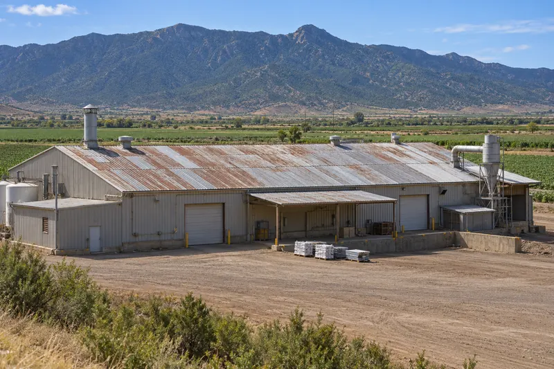 Agricultural processing building with a long, aged metal roof