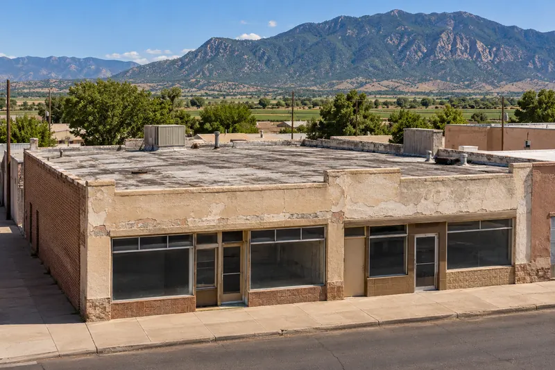Older main-street commercial building with an aged flat roof